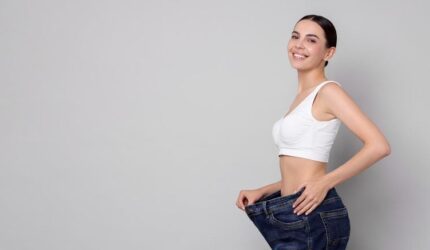 Wanita muda yang bahagia hasil penurunan berat badan longgar