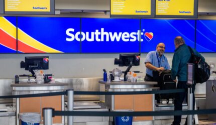 A Southwest Airlines employee assists a passenger during their check-in at the Austin-Bergstrom International Airport on April 18, 2023 in Austin, Texas. Southwest Airlines suffered a brief disruption in operations earlier this morning after a computer firewall issue forced the company to delay many of its flights. (Photo by Brandon Bell/Getty Images)