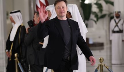 Elon Musk waves as he arrives for a state dinner at the Lusail Palace on May 14, 2025, in Doha, Qatar.