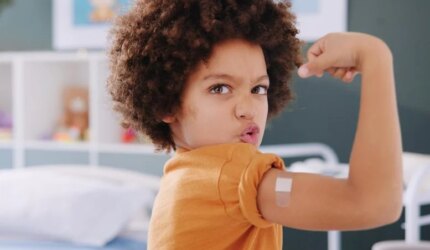 Anak Laki-Laki Melenturkan Lengan Bandaid Vaksin