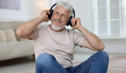 Pria Senior Tersenyum Mendengarkan Musik Headphone