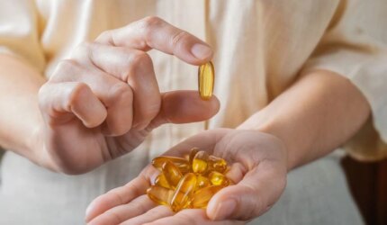 Wanita Memegang Suplemen Omega 3